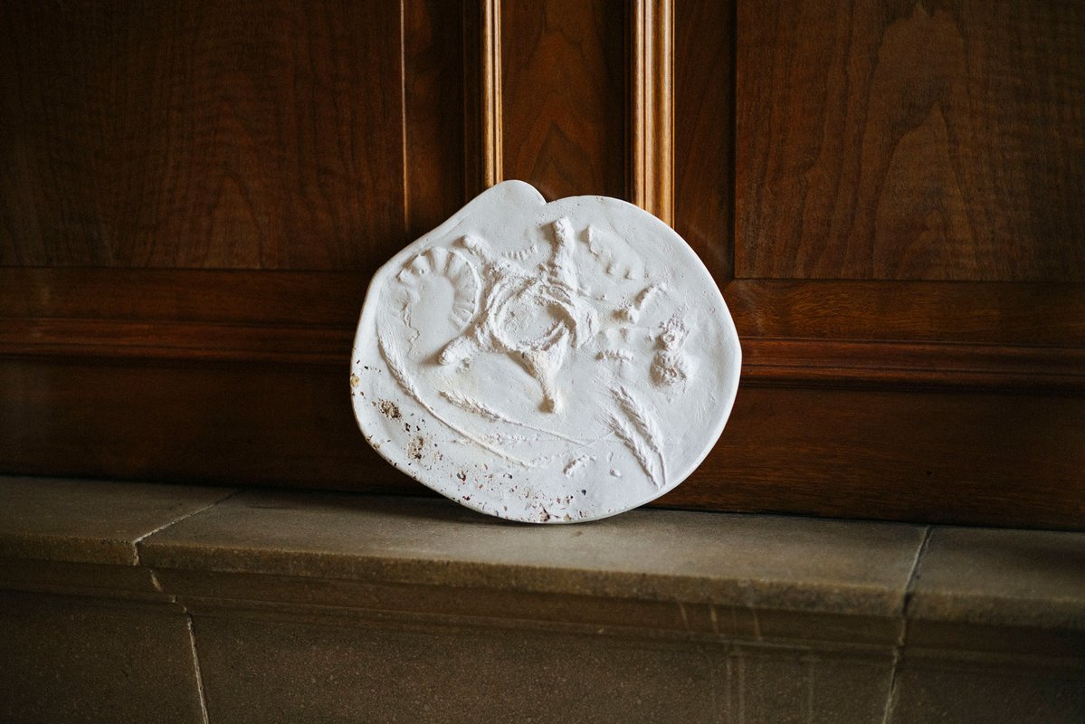 A white sculptural object photographed on a Tetley mantelpiece