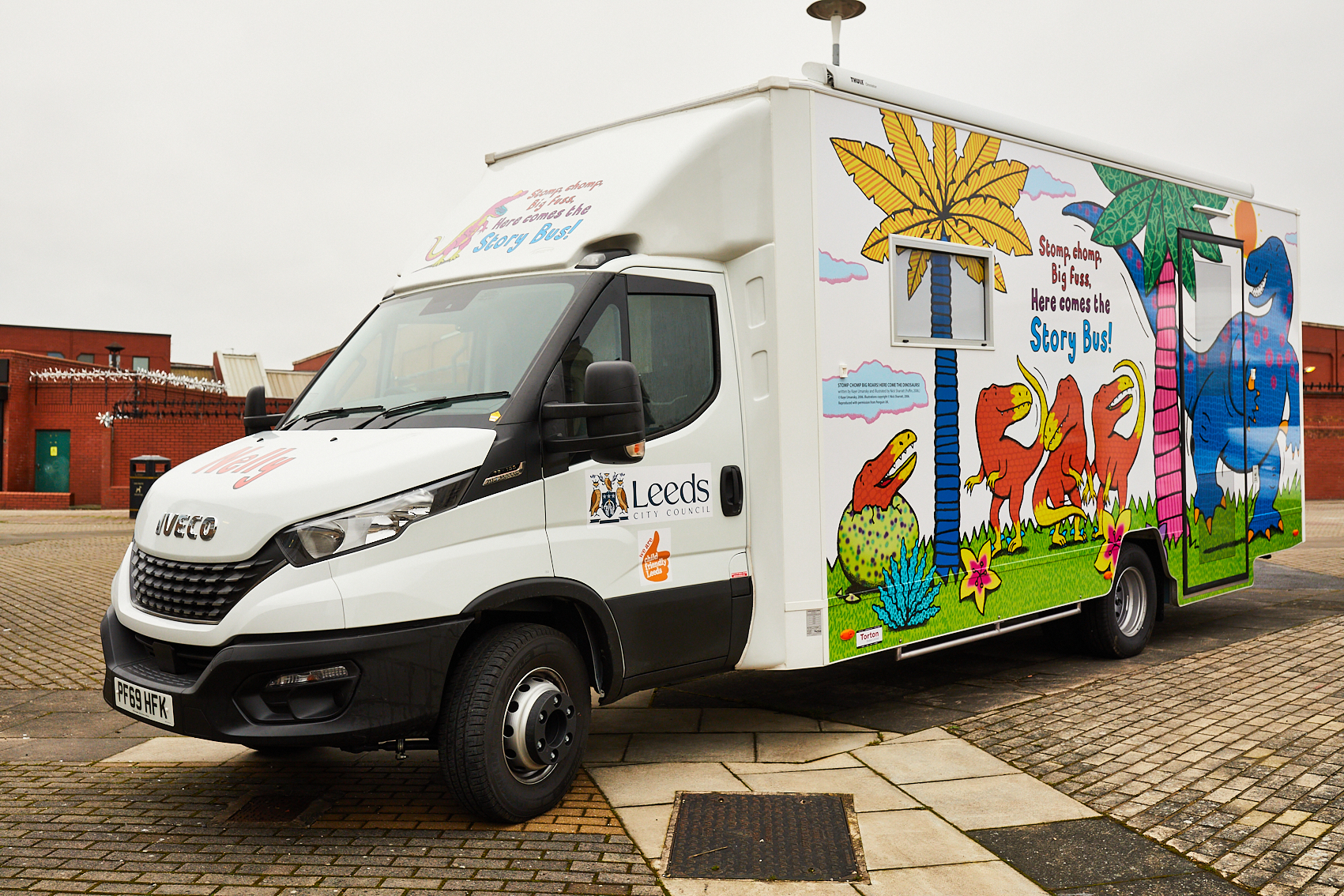 A white bus with dinosaur illustrations
