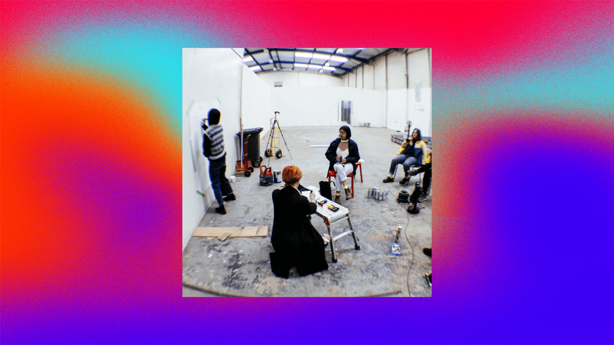 a photo of a group in an arts space making plans and writing ideas on a piece of paper on the wall