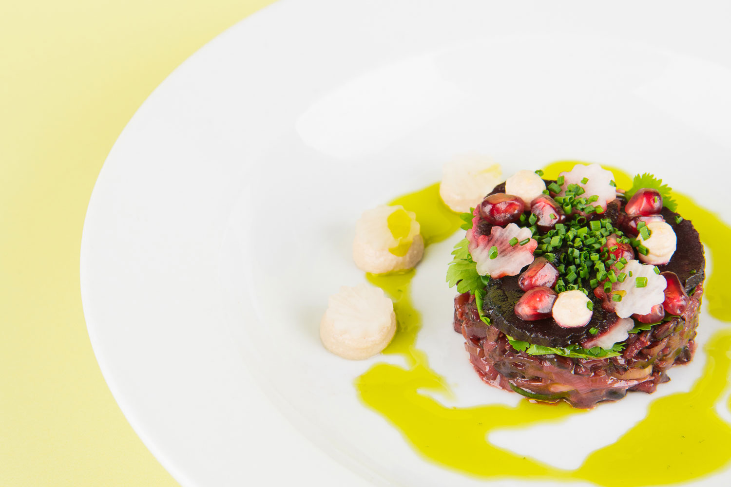 A close up photo of a beetroot and wild rice salad with pomegranate seeds on top