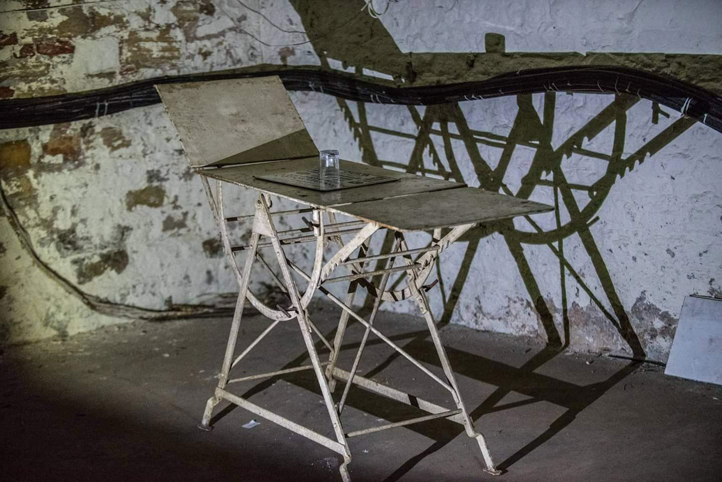 A shadow of a metal object in a dingy basement room