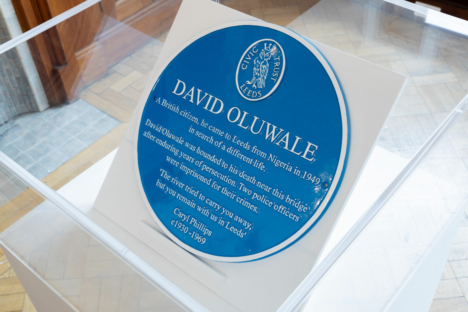 A blue plaque for David Oluwale in a vitrine as part of an exhibition at The Tetley