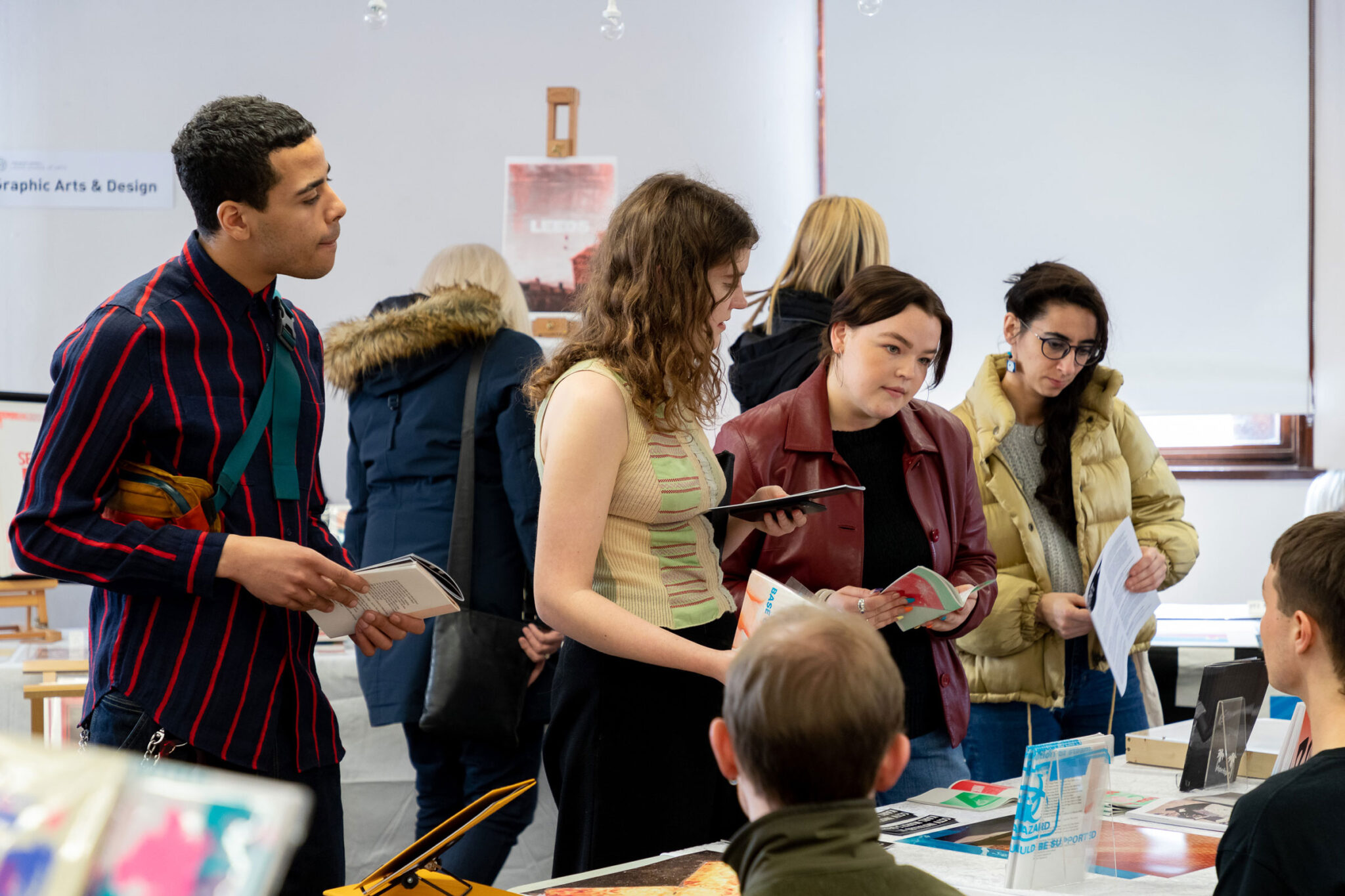 People looking at a stall at a zine fair