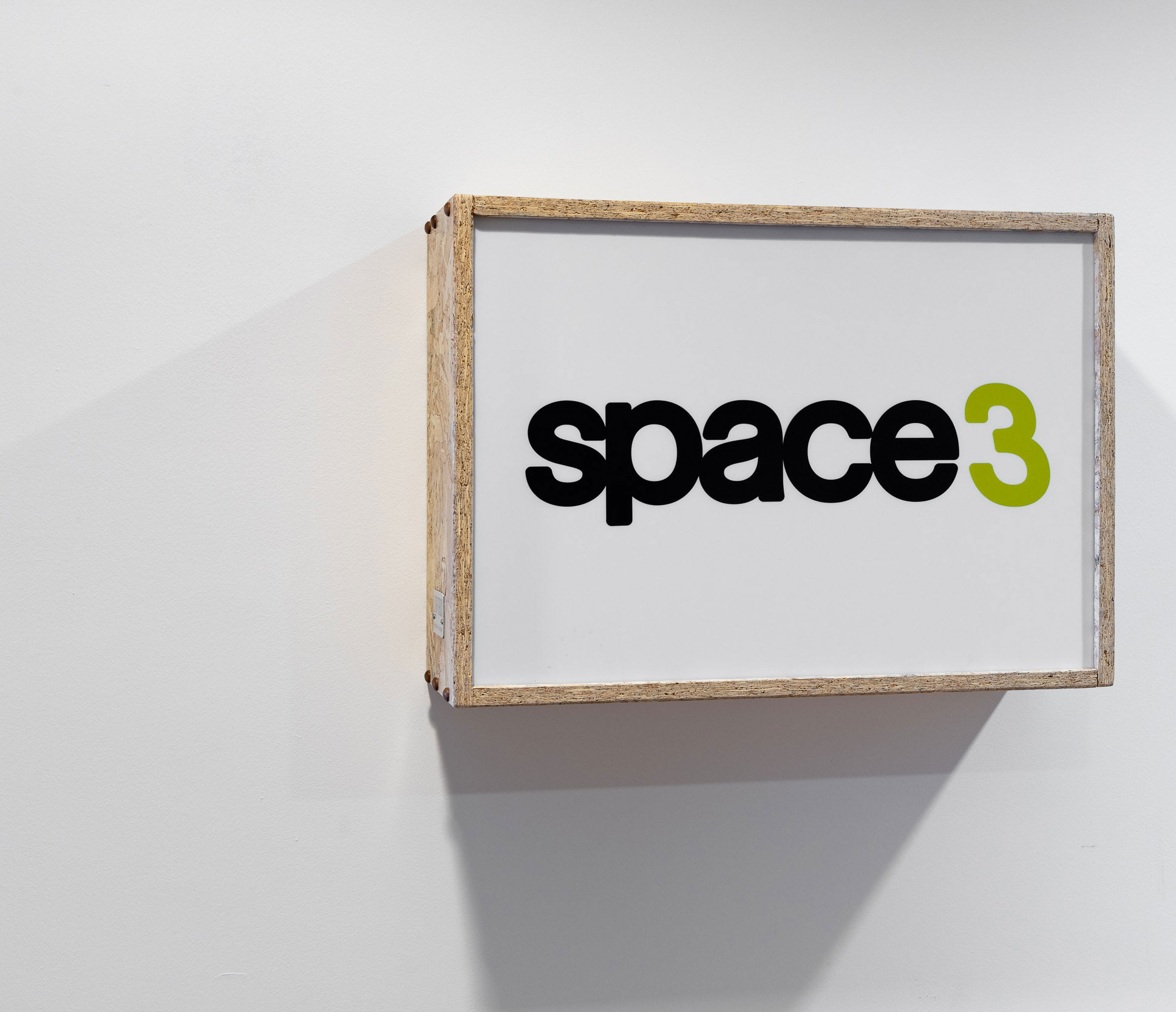 A light box on a white wall that reads 'space 3'