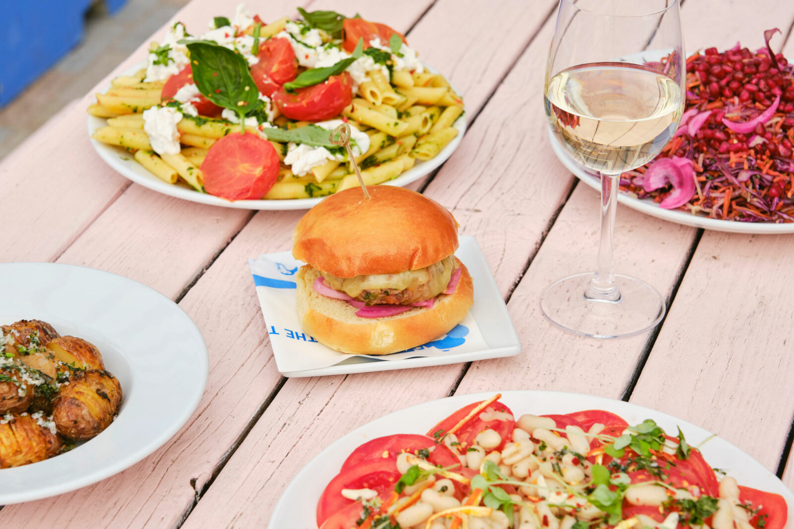 A pink picnic bench with BBQ food on it