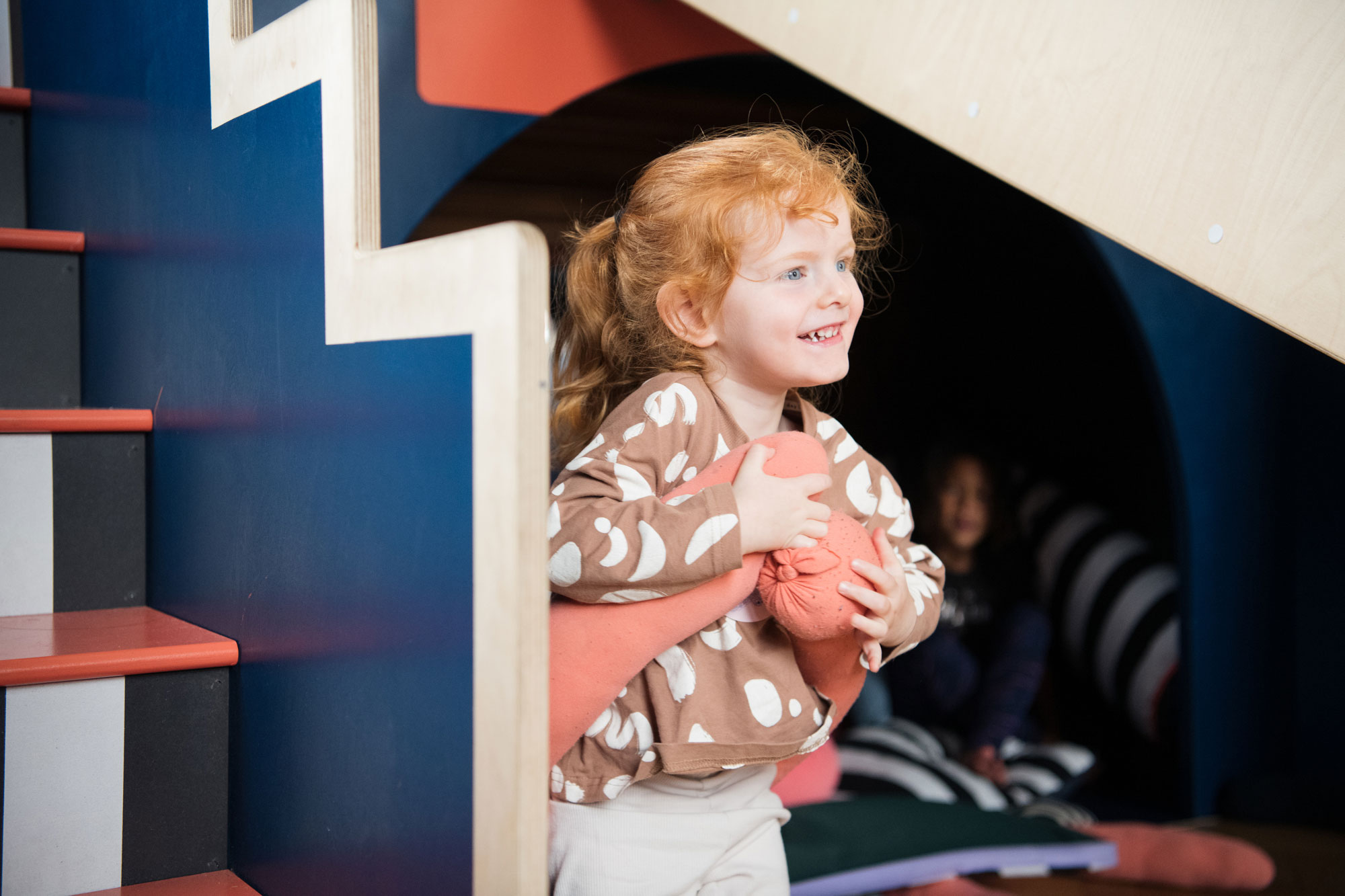 A young child playing and having fun in Tiny Tetley Studio, a free artist designed play space with art deco patterns