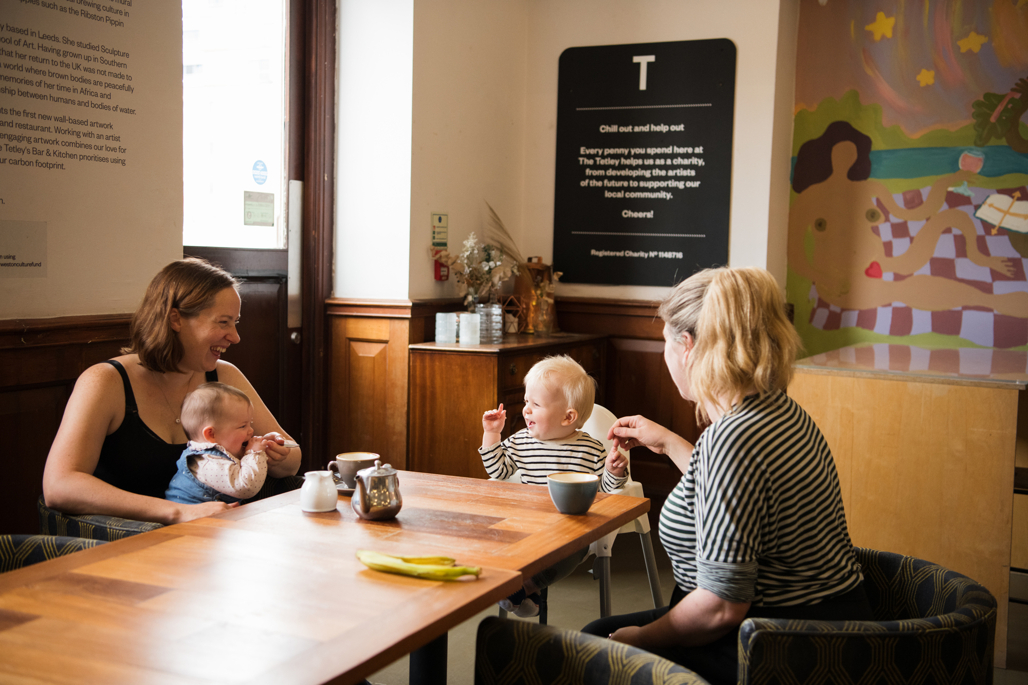Parents and their babies sit at a table enjoying refreshments
