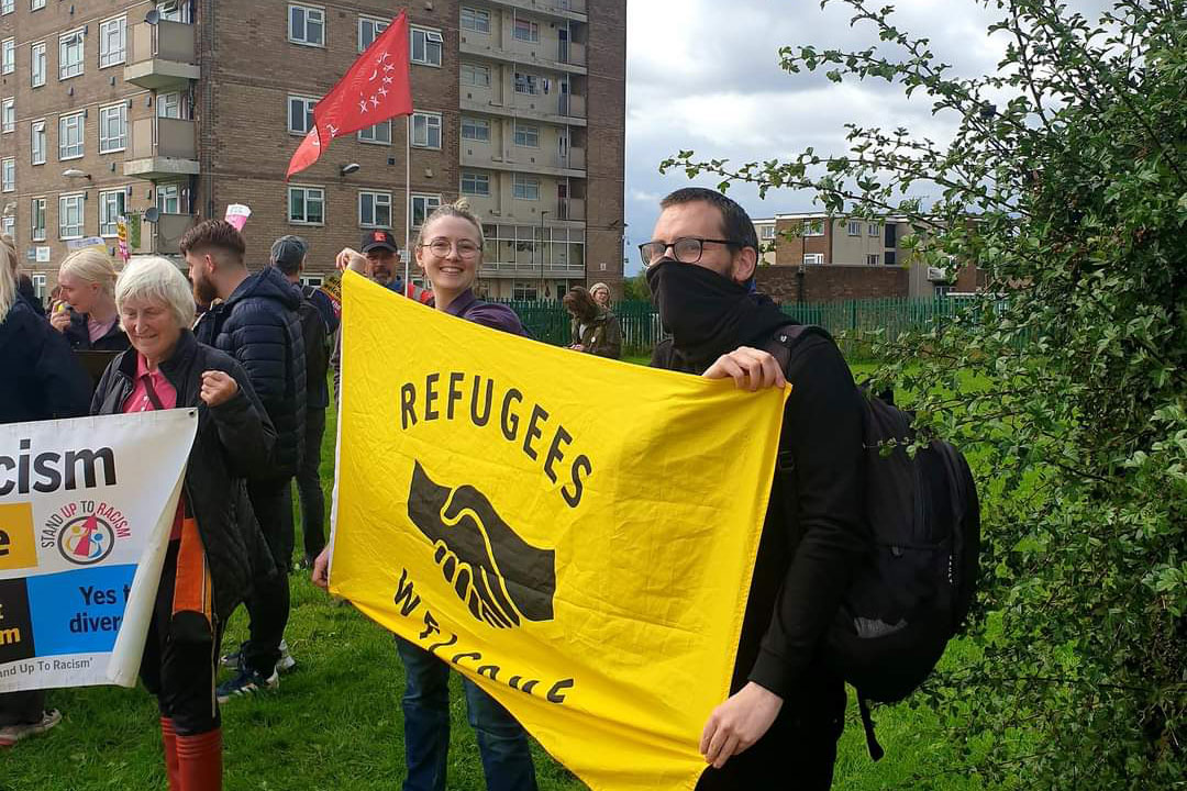 Vandal Factory hold a banner that reads Refugees Welcome