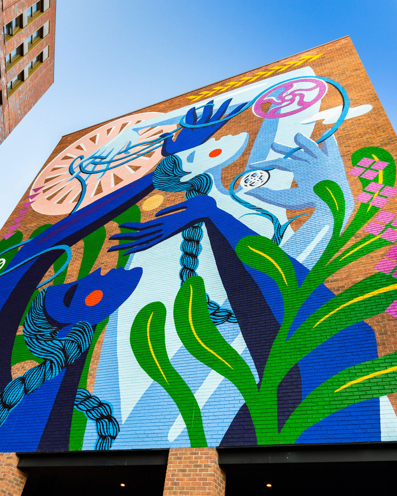 Brightly coloured mural with a figure entwined with cogs