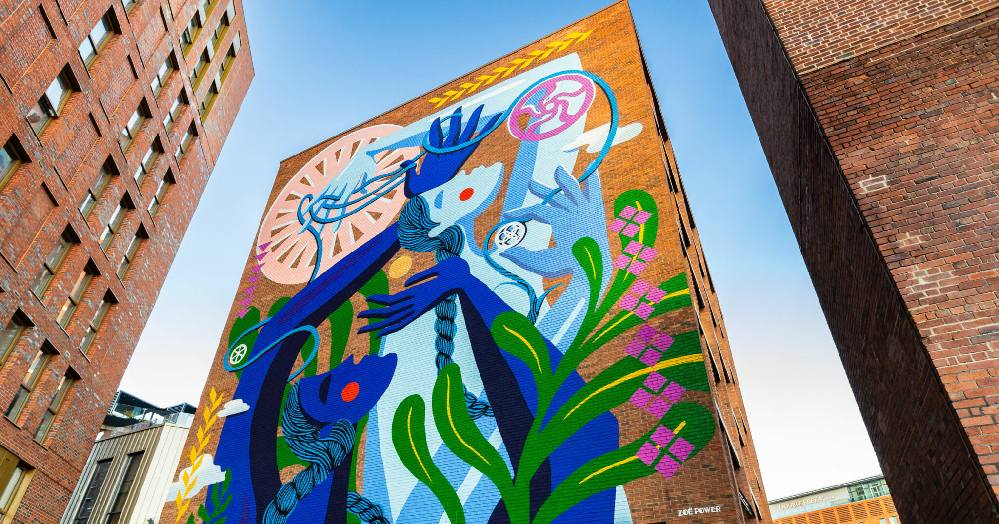 Brightly coloured mural with a figure entwined with cogs